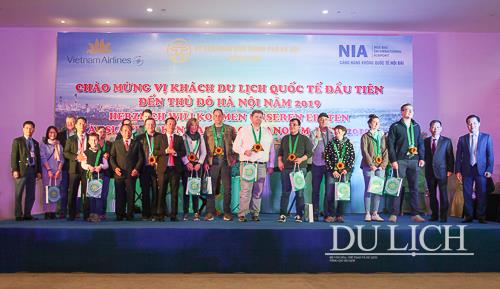 Các đại biểu tặng hoa và chụp ảnh lưu niệm cùng đoàn khách quốc tế đầu tiên của Du lịch Hà Nội năm 2019